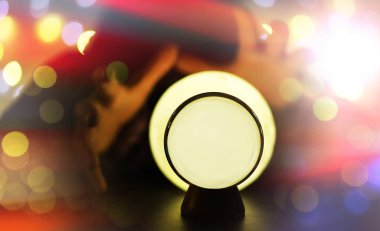 Yerde Bokeh 'le kristal küre var. Renkli ışık saçan cam top, yeni yıl kutlaması konsepti..