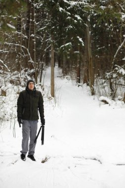 Kış ormanlarında sakallı adam. Çekici, mutlu, sakallı genç bir adam parkta yürüyor..