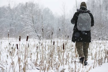 Palto ve İskoç kumaşlı yakışıklı bir adamın açık hava portresi. Sıradan kış modası.