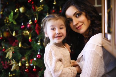 Yeni yıl ağacının yanında pijama ve yatak örtüsü giyen çekici bir kız. Noel atmosferi.