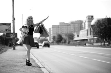 Küçük bir köpekle yürüyüşe çıkmış güzel bir sarışın.