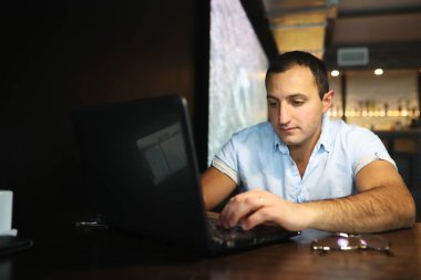 Kafede dizüstü bilgisayarın arkasında çalışan Ermeni yakışıklı adam.