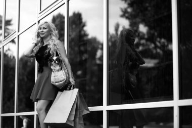 Küçük bir köpekle yürüyüşe çıkmış güzel bir sarışın.