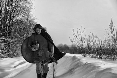 Defender'ı posta zırh genç savaşçı bir kılıç ve balta ile silahlı