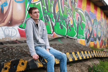 Tünelde kapüşonlu hip-hop yapan genç bir adam.