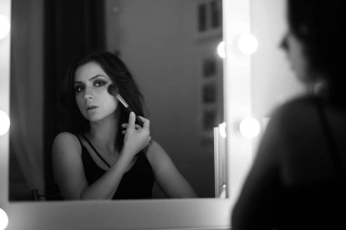 Güzel kız makyaj bir ayna önünde