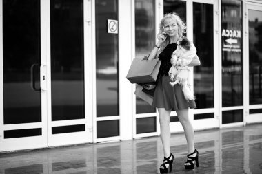 Küçük bir köpekle yürüyüşe çıkmış güzel bir sarışın.