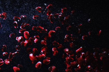 Olgun tatlı nar tohumlarına su damlaları düşer. Metnin için kopyalama alanı olan taze nar arkaplanı. Vejetaryen ve vejetaryen kavramı.