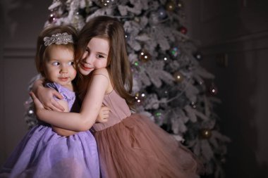 Noel ağacının önünde şık giyinmiş bir çocuk. Yeni yılı bekliyorum..