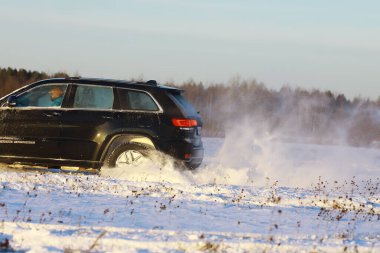 Araba, kışın tarlada. Off-road kış karları sürükleniyor. Olağanüstü spor, eğlence.
