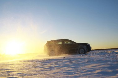 Araba, kışın tarlada. Off-road kış karları sürükleniyor. Olağanüstü spor, eğlence.