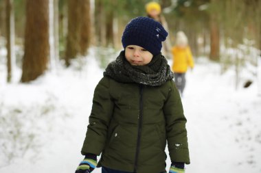 Mutlu bir aile kışın dışarıda karda oynar ve güler. Şehir parkı kış günü.