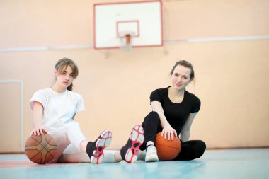 Genç kız öğrenci bir basketbol oynarken spor salonunda