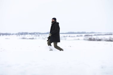 Kış ormanlarında sakallı adam. Çekici, mutlu, sakallı genç bir adam parkta yürüyor..