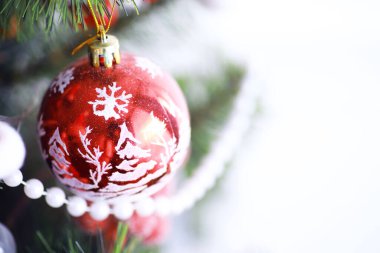 Noel tatili geçmişi. Gümüş ve kırmızı mücevher ağaçta asılı, kar ve bokeh ile, kopyalama alanı.