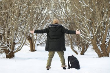 Kış ormanlarında sakallı adam. Çekici, mutlu, sakallı genç bir adam parkta yürüyor..