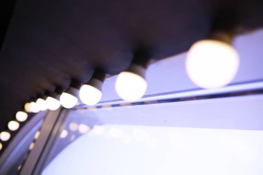 Kırmızı tavanda sirk ışıkları. Binanın tavanından sarkan lamba. Uzun kuyruklar halinde dizilmiş.