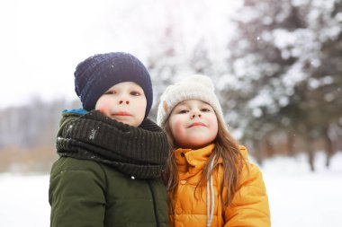Mutlu bir aile kışın dışarıda karda oynar ve güler. Şehir parkı kış günü.