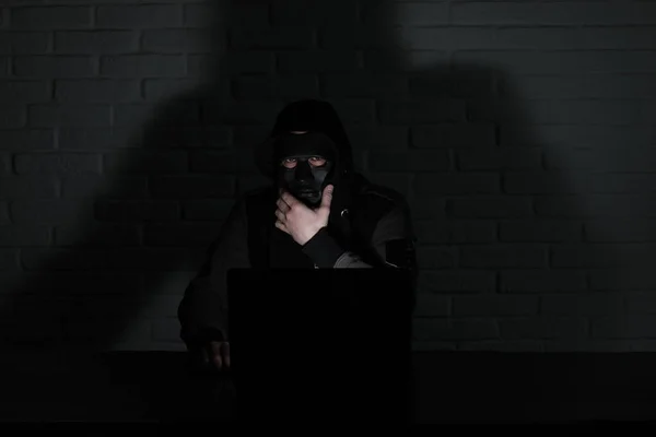 Hacker Con Máscara Negra Capucha Mesa Delante Del Monitor —  Fotos de Stock