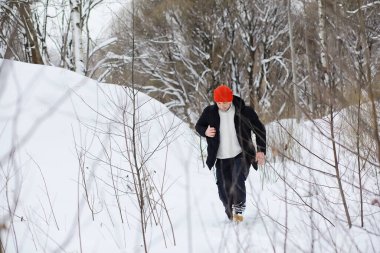 Kışın ormanda bir adam. Sırt çantalı bir turist kışın ormana gider..
