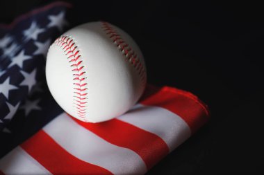 Amerikan geleneksel spor oyunu. Beyzbol mu? Kavram. Amerikan bayrağıyla birlikte beyzbol topu ve sopalar masada..