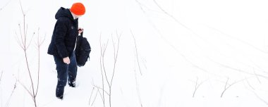 Kışın ormanda bir adam. Sırt çantalı bir turist kışın ormana gider..