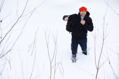 Kışın ormanda bir adam. Sırt çantalı bir turist kışın ormana gider..