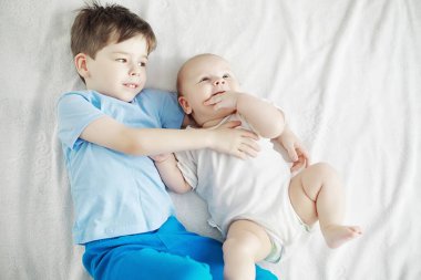 Çocuklar yeni doğan bebeğin yanında yatar, küçük kardeşim. Çocukların duyguları..