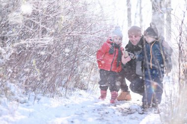 Çocuklar parkta ilk karla yürür.