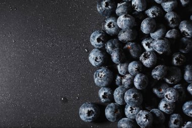 Olgun tatlı yaban mersinine su damlası. Metnin için fotokopi alanı olan taze yabanmersini arkaplanı. Vejetaryen ve vejetaryen kavramı. Yaban mersinli böğürtlenlerin makro dokusu. Yaban mersinli dokular kapanıyor.