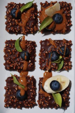 Fındıklı ve dutlu çikolatalı tatlı. Jöleli kahve bisküvisi ve meyveli fındık kırıntıları için tatlı atıştırmalık..