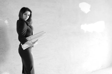 çizimler ve bir dizüstü bilgisayar ile inşaat sahasında kadın mimar