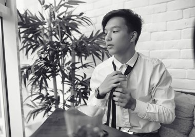 Genç bir Asyalı işadamı bir kafede ortak bekliyor. Bir kafede Koreli genç bir adam telefonda konuşuyor.