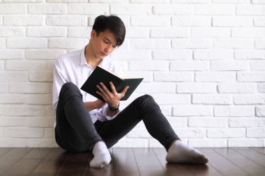 Elinde kitaplarla Asyalı genç bir öğrenci.