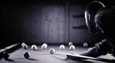 Sakallı bir adam büyük bir bilardo oynar. 3,5 metrelik havuzda parti. Kulüp oyununda erkekler için bilardo. Elinde ıstakayla bir adam piramidi kırar.