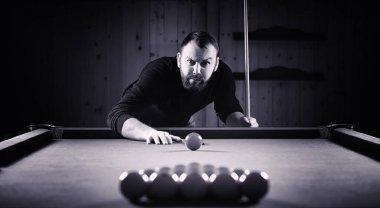 Sakallı bir adam büyük bir bilardo oynar. 3,5 metrelik havuzda parti. Kulüp oyununda erkekler için bilardo. Elinde ıstakayla bir adam piramidi kırar.