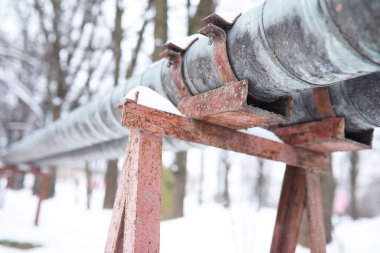 Karla kaplı gaz boru hattı ve kışın ağaçlarla kaplı kışın manzarası. Gaz borusu kışı geçirmek için.