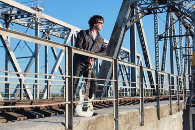 bir adam açık havada ve endüstriyel yatay olarak bir elektro gitar ile