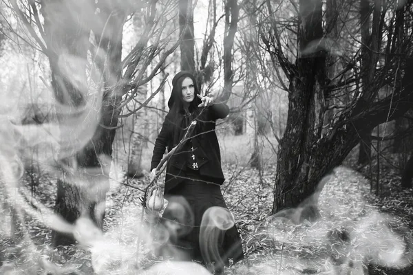 Bir kadın bir ritüel üzerinde yoğun bir orman içinde bir cadı elbiseli