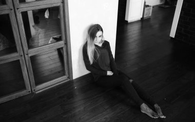 Genç bir kız büyük bir dairede dinleniyor.