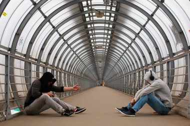 Kapüşonlu genç bir adam tünelde hip-hop yapıyor.