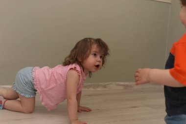 Bir katta bir odada oynayan genç çocuklar