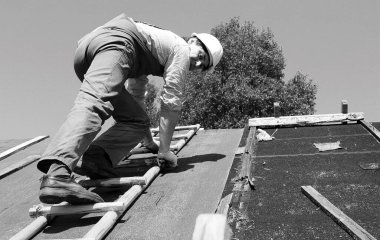 İnşaat alanında işçi kıyafetleri giyen bir adam.