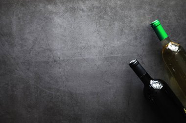 Masada bir bardak kırmızı şarap. Siyah şişe ve bir bardak şarap..