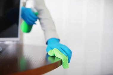 Ev temizliği konsepti. Yüzeylerin tozunu sil. Dezenfektan kapısı TV elektriğini kontrol ediyor. Evdeki karantinada hijyenik tedavi.