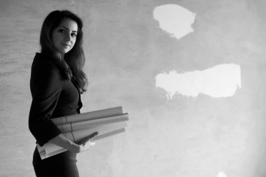 çizimler ve bir dizüstü bilgisayar ile inşaat sahasında kadın mimar