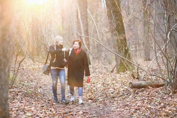 Sonbahar parkında yürüyüş yapan kadınlar.