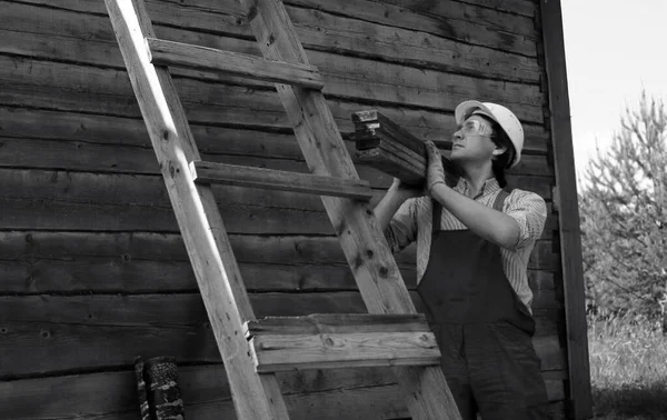 İnşaat alanında işçi kıyafetleri giyen bir adam.