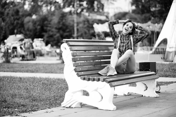 Siyah beyaz bir fotografta palyaço makyajı yapan tatlı bir kız.