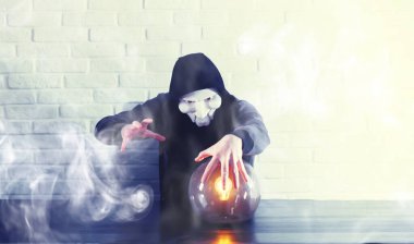 Masasında falcı topu olan bir adam.